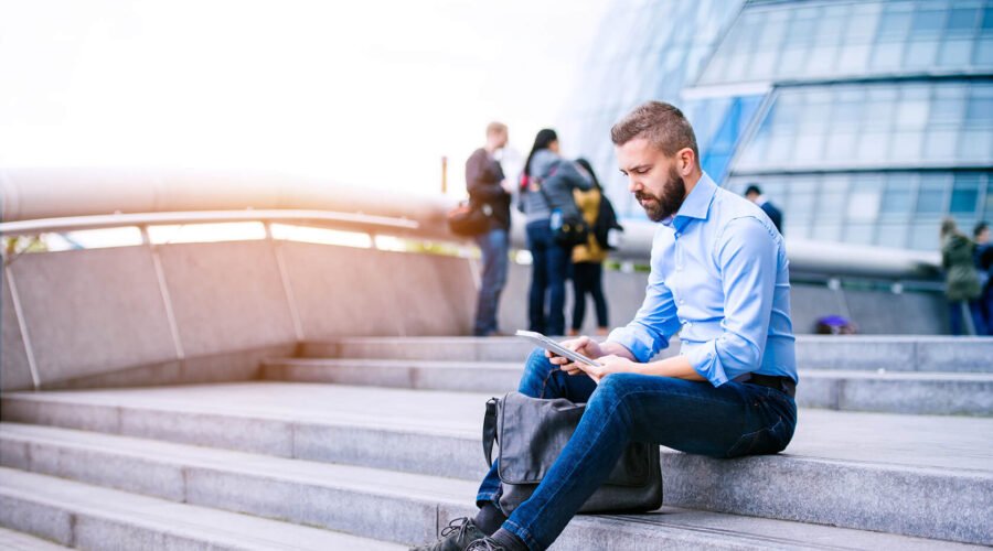 manager-with-tablet-sitting-on-stairs-london-city-PGB92TN